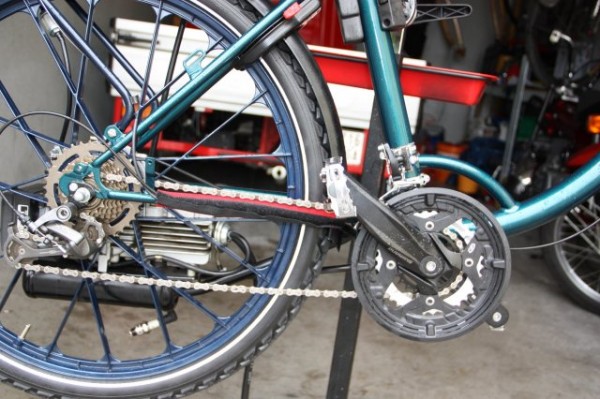 Auch die Shimano Alivio dreifach Kurbel f (123 mm Tretlagerachse) wurde jetzt gegen eine silberne Shimano Deore dreifach Kurbel (115 mm Tretlagerachse) ausgetauscht, damit die Kettenlinienführung besser passt.<br />Ich habe dafür eine Thun Pressinnenlager von Brucker Radlservive (von mir auch gehässiger weise Presswurstinnenlager genannt)  mit einer 127 mm Tretlagerachse verwendet.<br />Kettenblatt Abstufung 48/36/24.<br />Hinten habe ich ein Shimano Schraubkranz mit 14 bis 34 Zähne verwendet und ein XTR Inverse (negative Schaltwerk ) Schaltwerk für besseres und weicheres Schalten verbaut.<br />Der Umwerfer ist ein Shimano Umwerfer für Anlöttsockel den ich mit einer einfachen Schlauchrohrschelle aus den Baumark kombiniert habe.<br />Hier zu braucht man aber noch einen Anlöttsockel für Rennräder der eigentlich geschraubt wird.<br />Diesen habe ich aber an die  Schlauchrohrschelle durch einen Schweißer in meiner Arbeit anfertigen lassen, eben so wie den Seilzuggegenhalter.